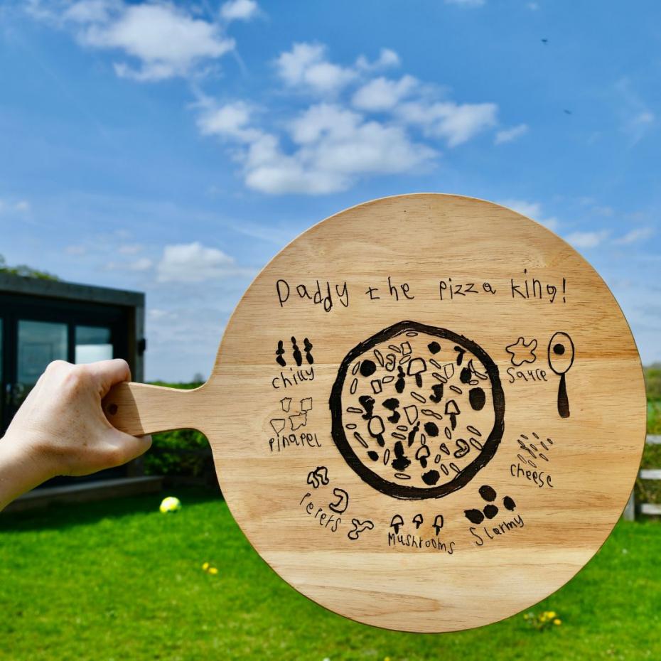 Engraved wooden pizza board with a child's drawing