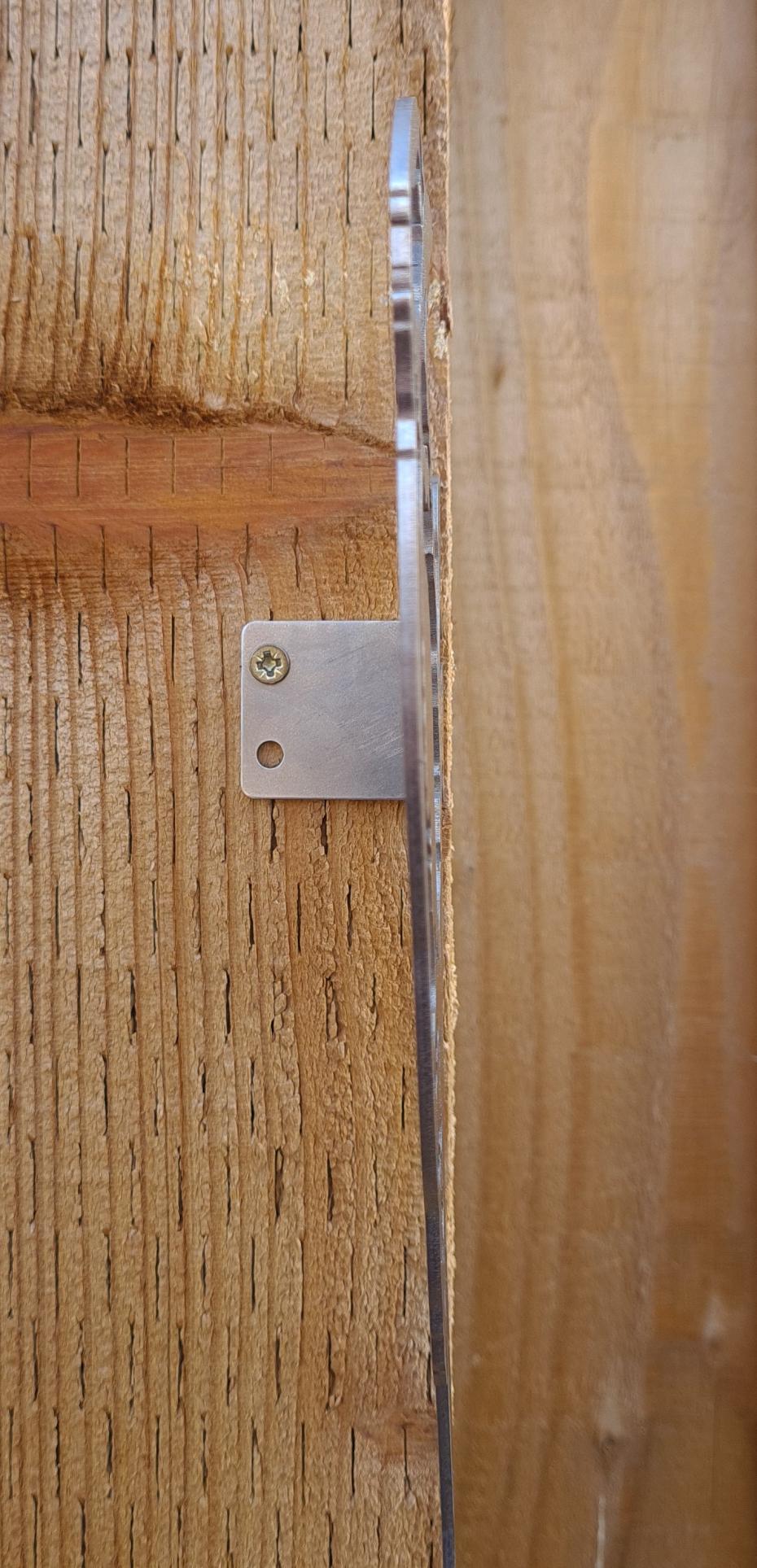 Unrusted Woodpecker Wall Mount In Situ On Wooden Fence Post To Show Mounting Bracket