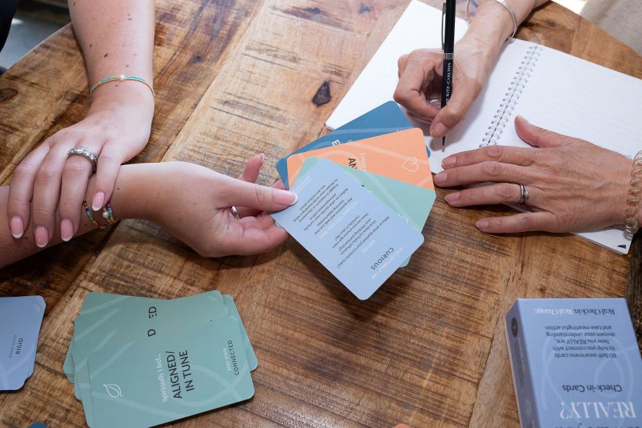 Close up two people using How are you REALLY? Check in cards