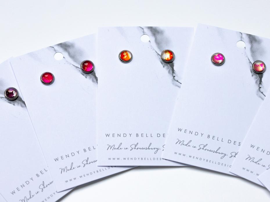Small hypoallergenic studs containing unique alcohol ink art sealed with a glass cabochon