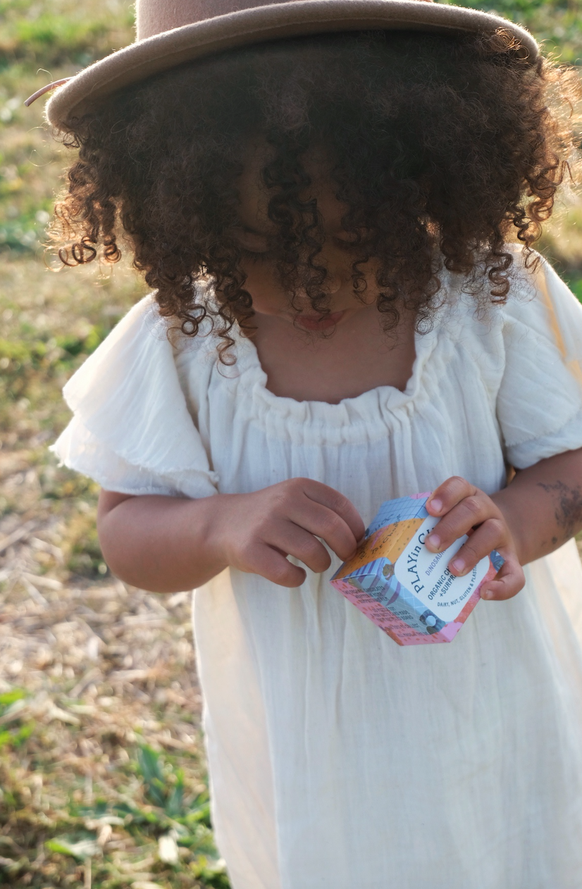 A girl opening her dinosaur box