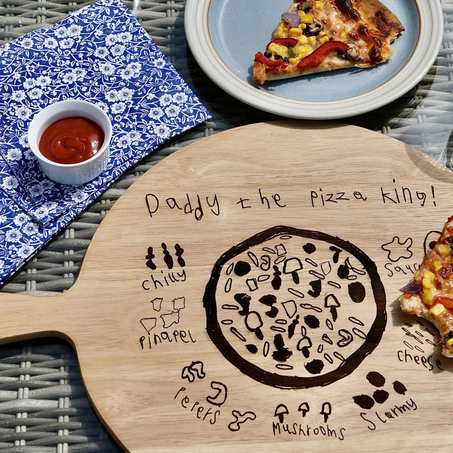 Engraved wooden pizza board with a child's drawing